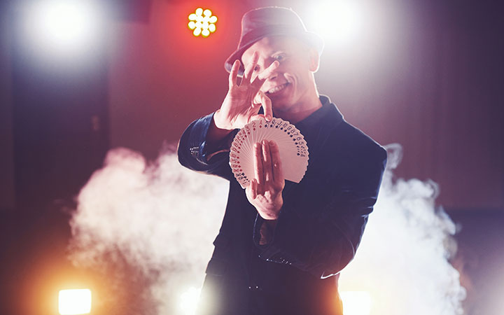 magician doing card tricks at a dispensary marketing and cannabis seo expo